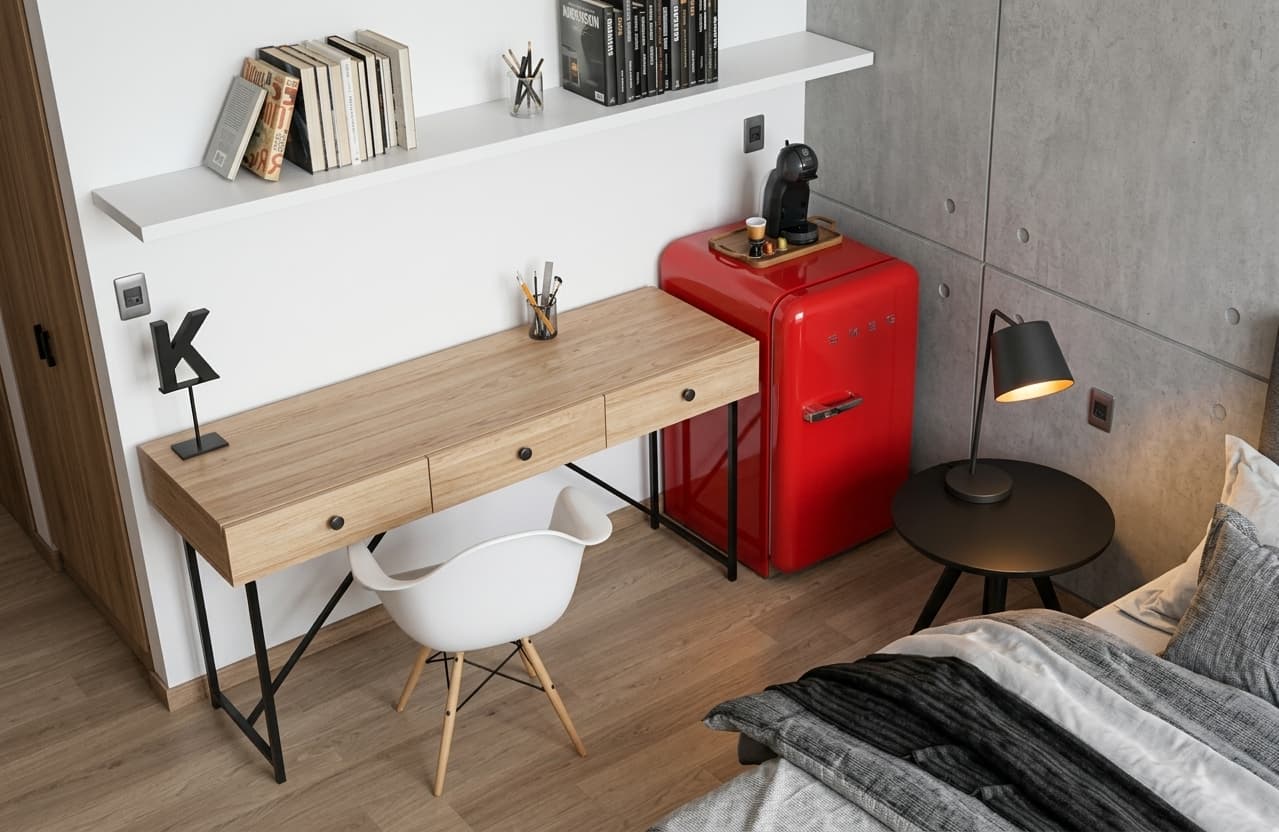 Detalle del escritorio de CRUDO 01, con mueble de madera y heladera compacta roja